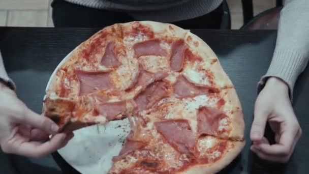 Mujer joven comiendo pizza sentada en la cafetería — Vídeos de Stock
