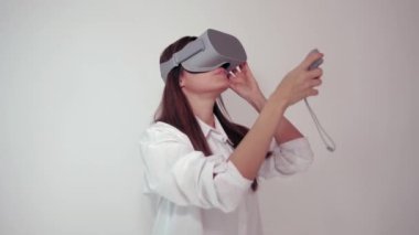 VR kulaklık genç kadın Etrafına bakar ve ne kadar şaşırtıcı harikalar. Beyaz arka planda sanal gerçeklik kask