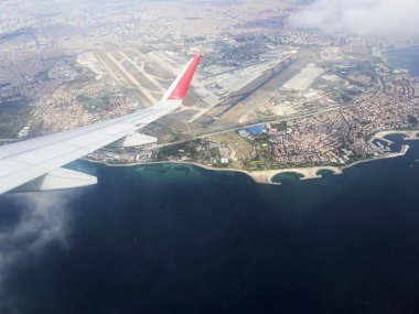 İstanbul Panoraması ve Yeni İstanbul Havaalanı uçak penceresinden, Türkiye. Uçak, bulut, mavi gökyüzü, Karadeniz ve Dünya'nın kanadında ki uçak porthole'undan görünümü.