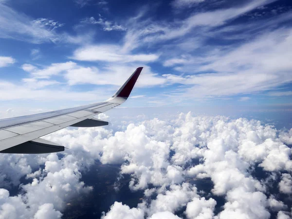 Vue à travers hublot d'avions sur l'aile d'avions, nuages, ciel bleu et la Terre à partir de la hauteur de dix mille mètres . — Photo