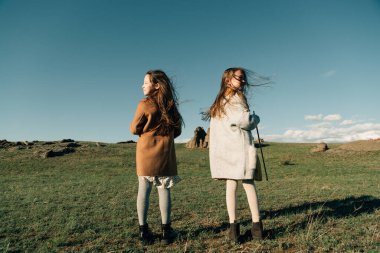 Dışarıda keman çalan iki kız kardeş gün batımında