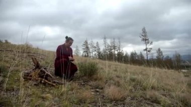 Budist keşiş bulutlu bir günde şifalı bitkiler topluyor.