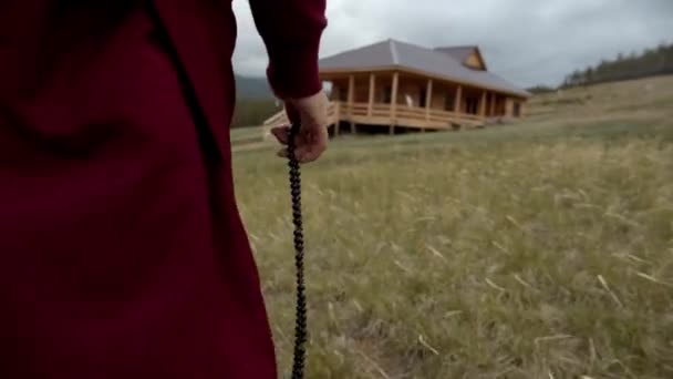 Boeddhistische Monnik Met Kralen Lopen Naar Ongebouwde Tempel — Stockvideo