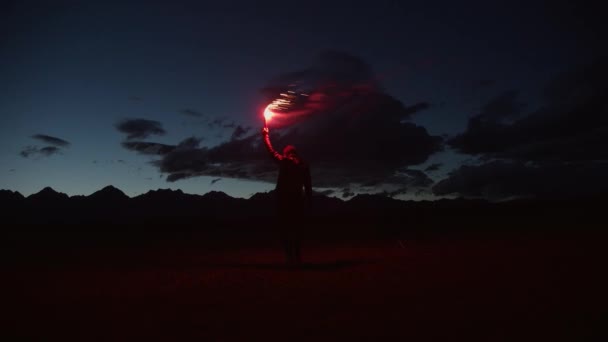 在山前的夜晚拿着红色火把的家伙 — 图库视频影像