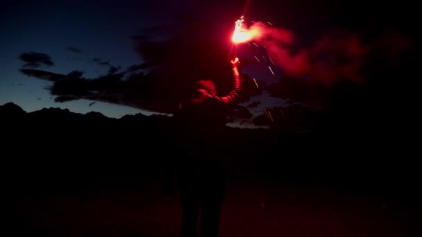 在山前的夜晚拿着红色火把的家伙 — 图库视频影像