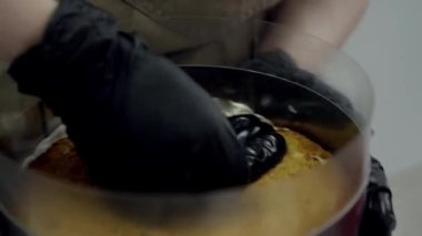 Pastanede pasta yapan kadın pastaya krema sürmüş.