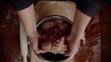 Kadın eli, doğranmış eti karıştırıyor.