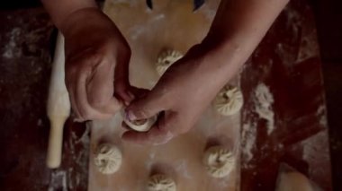 Kadın hamurla çalışıyor ve doğranıyor, ulusal buryat yemeği yapıyor.