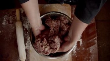 Kadın eli, doğranmış eti karıştırıyor.