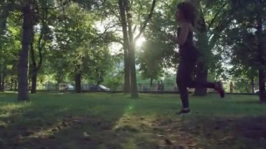 Parkta günbatımında çalışan kadın. Akşam saatlerinde parkta arkadan görünüşü çalışan kadın. Gün batımında Park yolda koşu fitness kadın