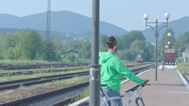 Wideo shootage chłopca, stojąc z jego rower na stacji kolejowej. — Wideo stockowe