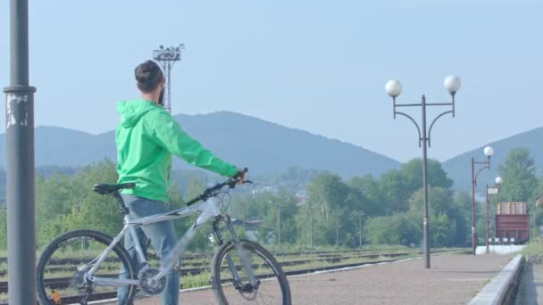 El hombre en forma mira las montañas . — Vídeos de Stock