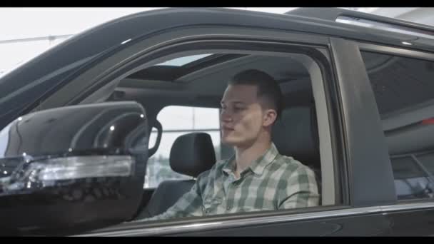 Nézd, új autó, auto szalon ül az ember oldaláról — Stock videók