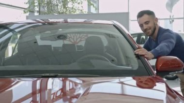 Adam elini dikkatli araba ön cam yakınındaki okşayarak..