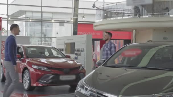 Dos jóvenes hombres guapos estrechando la mano después de la compra del coche . — Vídeo de stock