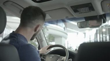 Geri adam oturan araba ve tutma tekerlek üzerinden görüntülemek