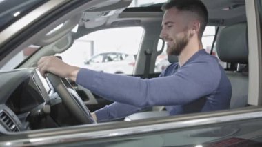 İyi bir araba ve gösteren anahtar oturan sakallı yakışıklı adam. 