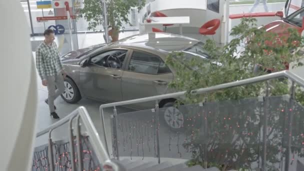 Vue d'en haut de l'homme assis en voiture dans le salon de l'automobile — Video