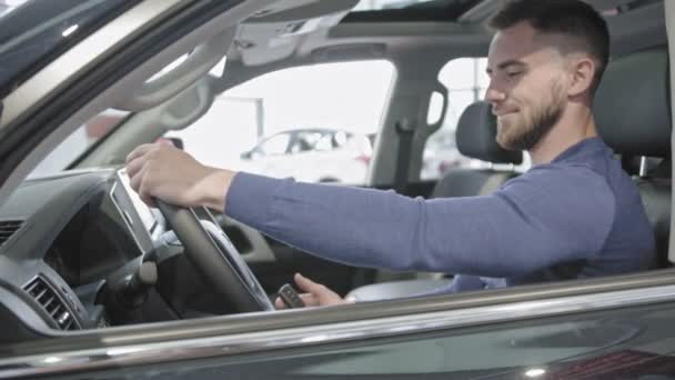 Vista lateral del hombre sentado en auto y disfrutando del interior del coche — Vídeos de Stock
