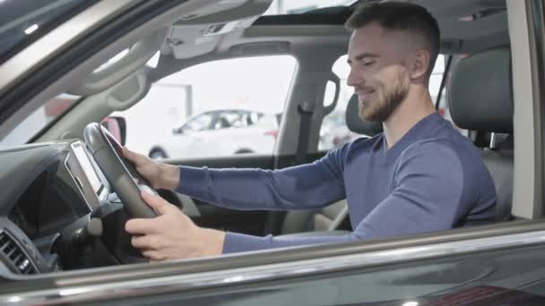 Mann hält Hände am Lenkrad und genießt neues Auto. — Stockvideo