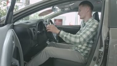 Adam şoför koltuğunda oturur. İç lambayı mutlu kendine güvenen delikanlı inceliyor salon araba