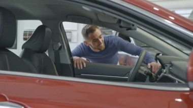 Bir sakallı şık adam lüks araba yürüyüş ve içinde araba bayilik dokunmadan yeni otomobil seçimi.