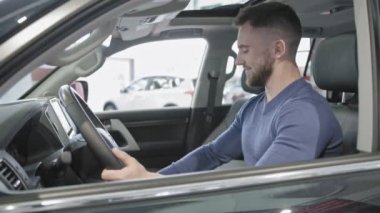 Mutlu bir adam closeup bir tür yeni arabada oturur.