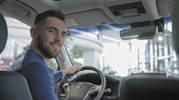 Hombre disfrutando del interior del coche en el nuevo automóvil en el salón de automóviles — Vídeos de Stock