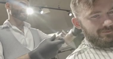 Kuaför Salonu saç kesme işlemi closeup. Clipper elinde tutmak ve şekil saç sandalyede oturan erkek istemciye düzeltme nitelikli Kuaför.