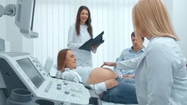 Gros plan, médecin et patient au Bureau des diagnostics ultrasonores. Jeune femme enceinte sur une revue au Centre médical — Video