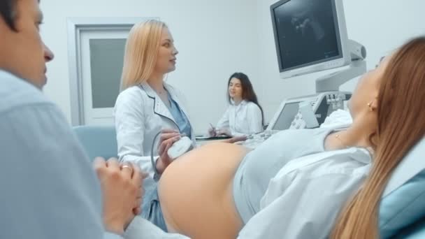 Mujer embarazada y pareja en busca de ecografía del bebé con el médico . — Vídeos de Stock