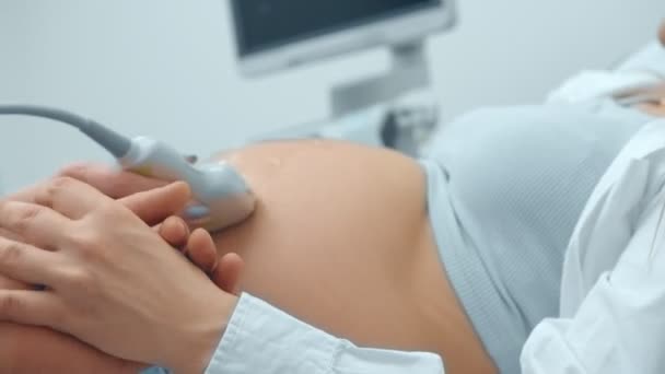 Médico mujer realizando un procedimiento de ultrasonido en embarazada hermosa mujer . — Vídeos de Stock