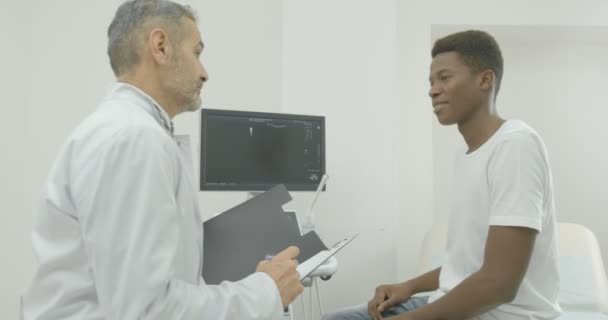 Conceito de medicina, saúde e tecnologia. Médico masculino conversando com paciente no escritório . — Vídeo de Stock