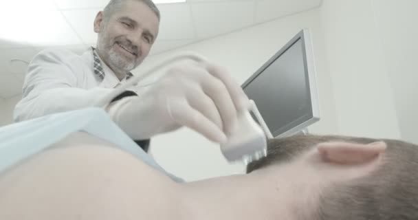 Боковой вид бородатого мужчины, лежащего на осмотре в медицинском кабинете. Врач в медицинской белой перчатке с помощью ультразвукового зонда для обследования . — стоковое видео