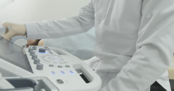 Diagnostyka ultradźwięków węzłów chłonnych na szyi. Brodatego człowieka leżącego w gabinecie lekarskiej. — Wideo stockowe