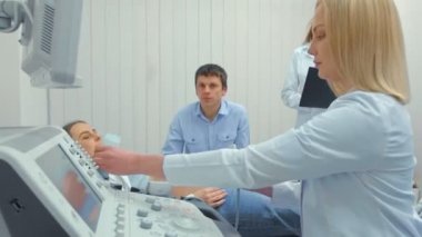 Yakın çekim, doktorun hastanede hamile bir kadına ultrason taraması yapıyor. Doğum doktoru gelecek anne göbek üzerinde dönüştürücü hareket.