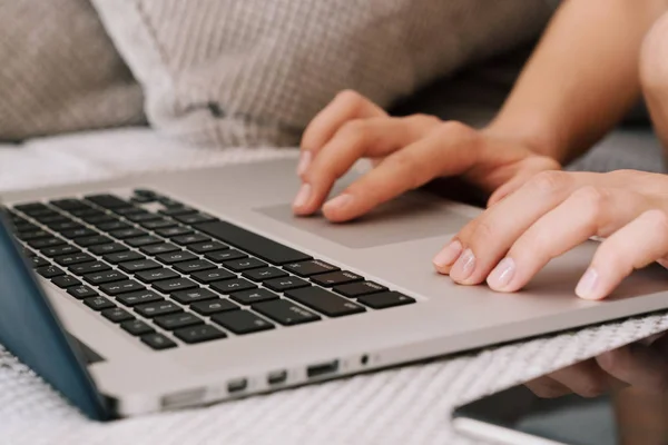 Female fingers typing on laptop keyboard.