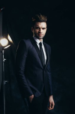 Siyah malzeme arka plan ve sinema ışığı ile bir stüdyoda yakışıklı adam Portresi.