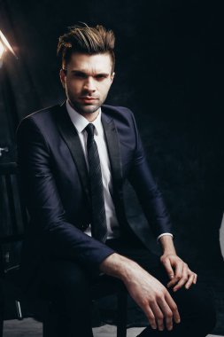 Bir stüdyoda moda erkek portresi. Resmi siyah takım elbise.