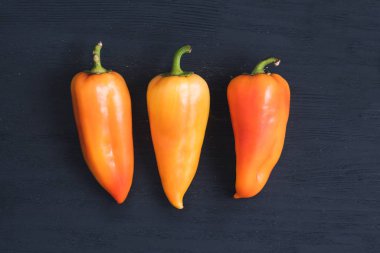 Koyu mavi ahşap arka plan üzerinde sarı taze kırmızı biber