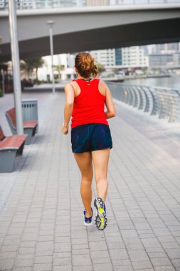 Kırmızı üst ve mavi şort marina açık havada çalışan genç uygun kız