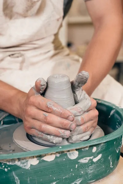 Creating a jar or vase of brown clay close-up. Master crock. Man