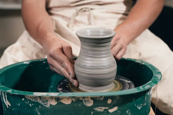 Giovane uomo che fa pentola di ceramica sulla ruota ceramica. Creazione di vasetti — Foto Stock