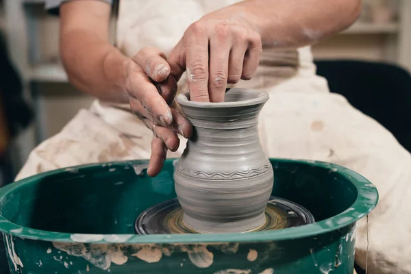 Giovane uomo che fa pentola di ceramica sulla ruota ceramica. Creazione di vasetti — Foto Stock