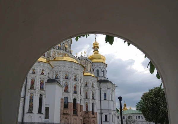 A vista da Catedral Uspensky é o mosteiro da caverna de Kiev através da cerca — Fotografia de Stock