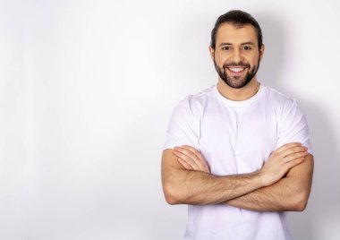 Gülümseyen beyaz arka plan üzerinde beyaz t-shirt yakışıklı adam