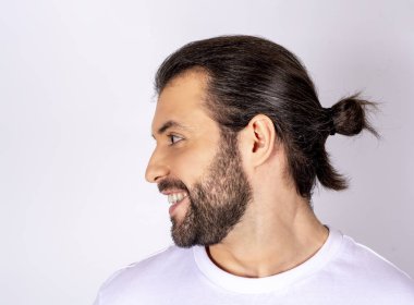 Yakışıklı adam gülümseyerek, profil, yakın çekim, seyir beyaz bir arka plan üzerinde beyaz t-shirt