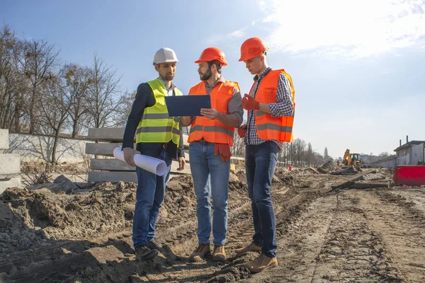 Male Builders Workers Engineers Construction Site Looking Drawings Helmets — Stock Photo, Image
