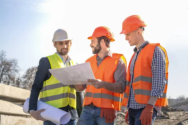 Constructores Hombres Ingenieros Trabajadores Sitio Construcción Que Buscan Dibujos Cascos — Foto de Stock