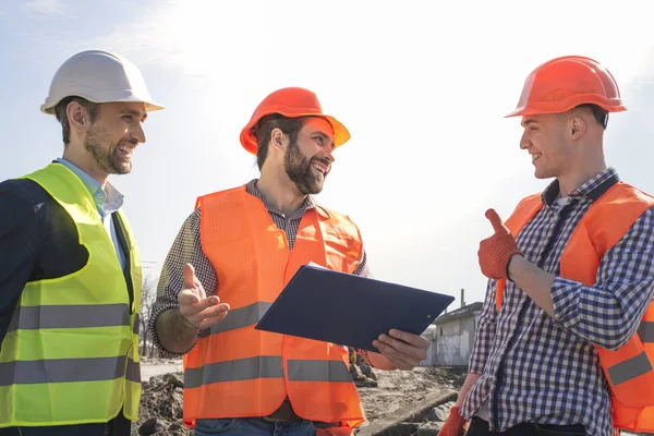 Male Builders Workers Engineers Construction Site Looking Drawings Helmets — Stock Photo, Image
